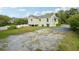 Exterior view of a charming light-green house with a gravel driveway at 187 Main Nw St, Lilburn, GA 30047