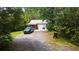 House exterior showcasing a single-story home with a gravel driveway and wooded surroundings at 268 Arnold Mill Rd, Woodstock, GA 30188