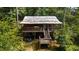Two-story house with a metal roof, deck, and a car parked below at 268 Arnold Mill Rd, Woodstock, GA 30188