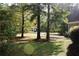 Landscaped side yard with mature trees and a partial view of the neighborhood at 7025 Fletcher Dr, Winston, GA 30187