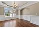 Bright dining room with hardwood floors, chandelier, and wainscoting at 309 Marbella Way, Mcdonough, GA 30252