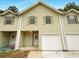 Light-yellow townhouse exterior with a white garage door at 1206 Pine Tree Trl # 12C, Atlanta, GA 30349