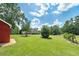 Large backyard with lush green grass and a red storage building at 3112 Highway 155 N, Mcdonough, GA 30252