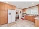 Modern kitchen with oak cabinets, white appliances, and tile flooring at 3112 Highway 155 N, Mcdonough, GA 30252