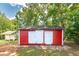 Red storage shed with white doors in wooded area at 3112 Highway 155 N, Mcdonough, GA 30252