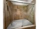 Bathroom with a jetted tub and glass shower door at 200 Renaissance Ne Pkwy # 302, Atlanta, GA 30308