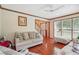 Bright living room with hardwood floors, neutral furniture and views to entryway and backyard at 9334 Woodsboro Ct, Jonesboro, GA 30236