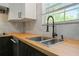 Modern kitchen sink with butcher block countertops and a black faucet at 6584 Sleepy Hollow Ln, Morrow, GA 30260
