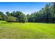Side yard of the house with green lawn and trees at 725 Holland Rd, Powder Springs, GA 30127