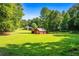 Spacious backyard with red barn and lush greenery at 725 Holland Rd, Powder Springs, GA 30127