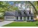 Recently renovated house exterior, showcasing a white facade, gray roof, and spacious driveway at 1161 Appian Way, Lawrenceville, GA 30046