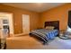 Bright bedroom with carpeted floors, a striped comforter on the bed, and an orange wall at 3756 Wood Hollow Way, Snellville, GA 30039