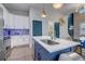 Modern kitchen with white cabinets, blue island, stainless steel appliances, and stylish backsplash at 975 Welch Sw St, Atlanta, GA 30310