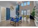 Bright living room with glass dining table, blue chairs, and access to an outdoor patio at 975 Welch Sw St, Atlanta, GA 30310