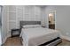 Spacious bedroom with gray upholstered bed, nightstands, and an accent wall at 975 Welch Sw St, Atlanta, GA 30310