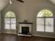 Spacious living room with hardwood floors, fireplace, and arched windows at 1950 Holland Park Dr, Buford, GA 30519