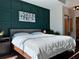 Main bedroom with dark green accent wall and wood flooring at 923 Peachtree Ne St # 830, Atlanta, GA 30309