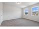 Bright bedroom with grey carpet and two windows at 6300 Misty Hill Ln, Buford, GA 30518