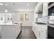 White kitchen with island, stainless steel appliances, and hardwood floors at 6300 Misty Hill Ln, Buford, GA 30518