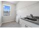 Laundry room with sink, granite countertop, and shelving at 6300 Misty Hill Ln, Buford, GA 30518