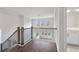 Upstairs hallway with wood flooring, railing, and access to bathroom at 6300 Misty Hill Ln, Buford, GA 30518