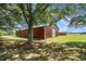 Large red barn with a large door and a tree in front at 1170 Lowell Rd, Carrollton, GA 30116