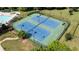 Two well-lit tennis courts with surrounding green space at 4550 Fernbrook Pl, Cumming, GA 30040
