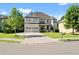 Two-story house with brick facade, three-car garage, and landscaped lawn at 4550 Fernbrook Pl, Cumming, GA 30040