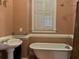Bathroom with pedestal sink, clawfoot tub, and window with shutters at 490 Hill Se St, Atlanta, GA 30312