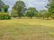 Large open field with mature trees and landscaping at 1152 Harbins Rd, Dacula, GA 30019