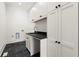 Bright laundry room with white cabinets and dark slate floor at 1645 Mayfield Rd, Alpharetta, GA 30009