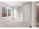 Simple bedroom with a closet and large window, showcasing neutral colors at 4640 Callan Trl, Cumming, GA 30041