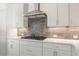 Kitchen detail showcasing gas cooktop and stylish backsplash at 4640 Callan Trl, Cumming, GA 30041