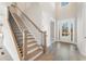 Elegant wooden staircase with black metal railing in a light-colored foyer at 4640 Callan Trl, Cumming, GA 30041