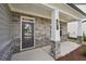 Covered front porch with stone facade and modern front door at 1522 Dover Creek Ln, Lawrenceville, GA 30045