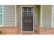 Close-up of the dark wood front door with a decorative welcome mat at 1800 Pearson St, Loganville, GA 30052