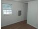 Simple bedroom with wood flooring, beadboard walls, and an exterior door at 64 Luther Knight Se Rd, Cartersville, GA 30121
