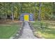 Gray shed with yellow door and stone pathway at 103 Royal Way, Mcdonough, GA 30252