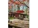 Spacious deck with red umbrella, table and chairs, overlooking wooded area at 5635 Lake Forrest Dr, Atlanta, GA 30342