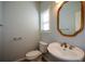 Small bathroom with pedestal sink, toilet, and gold mirror at 6865 Cowan Mill Rd, Winston, GA 30187