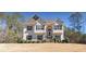 Two story home with beige exterior, black shutters, and landscaping at 10 Argyll Way, Covington, GA 30014