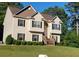 Two story home with beige siding, black shutters, and a wooden staircase at 10 Argyll Way, Covington, GA 30014