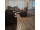 Living room with brown leather reclining furniture and wood-look floors at 340 Mcgiboney Ln, Covington, GA 30016