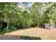 Wooded backyard with a large shed and open grassy area at 100 Point Rd, Whitesburg, GA 30185