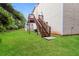 Landscaped backyard with wooden deck and stairs leading to the house at 6393 Shadow Sq, Lithonia, GA 30058
