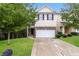 Two-story townhome with a beige exterior, two-car garage, and well-manicured lawn at 6393 Shadow Sq, Lithonia, GA 30058