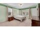 Well-lit bedroom with light green walls, carpeted floors, and a wooden dresser at 3216 Guynelle Dr, Marietta, GA 30066