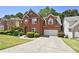 Brick two story house with a large green lawn and driveway at 230 Ridge Bluff Ln, Suwanee, GA 30024