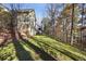Sloped backyard with mature trees and partial house view at 403 Pebblebrooke Ln, Canton, GA 30115