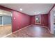 Finished basement room with maroon walls and wood-look flooring at 403 Pebblebrooke Ln, Canton, GA 30115